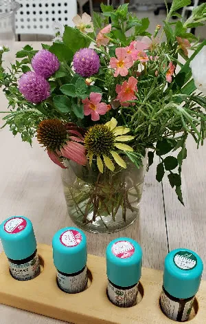 アロマテラピーの精油ボトルと花束｜ヴィーナース メディカルハーブLABO 東京秋葉原